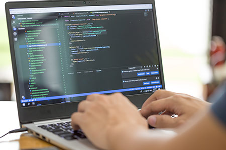 AddIn-PRogrammierung: Mann arbeitet am Laptop, auf dem Code zu sehen ist AddIn-PRogrammierung: Mann arbeitet am Laptop, auf dem Code zu sehen ist