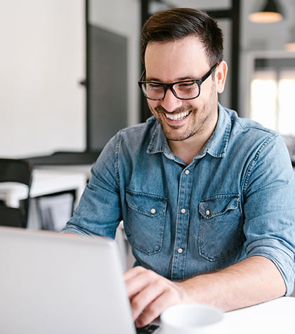 Word-Vorlagen: Mann sitzt lachend vor einem Laptop